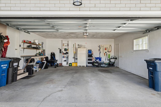 garage featuring a garage door opener and freestanding refrigerator