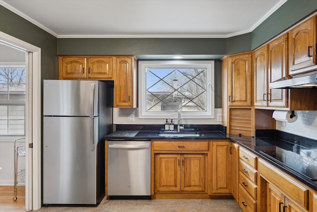 kitchen featuring dark countertops, appliances with stainless steel finishes, decorative backsplash, and a sink