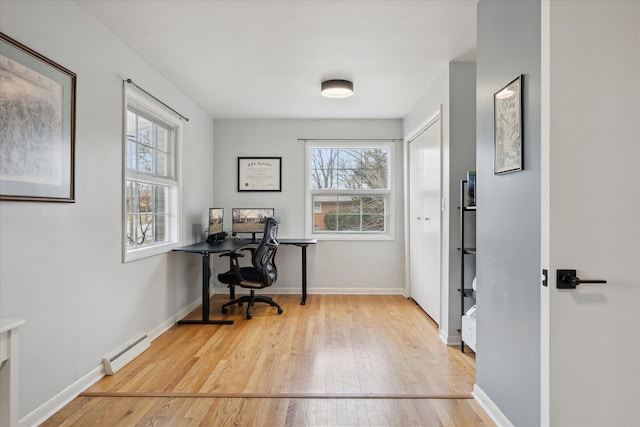 office area with baseboards, a baseboard radiator, and hardwood / wood-style floors