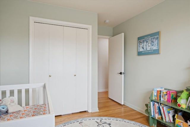 bedroom with baseboards, a closet, and light wood-type flooring