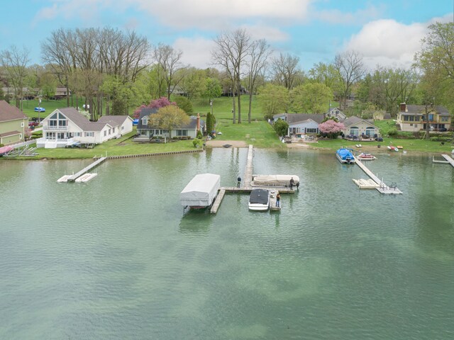dock area with a water view, a residential view, and view of scattered trees