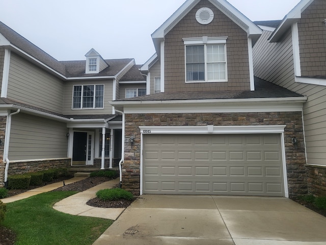 view of front of home with stone siding, driveway, and an attached garage