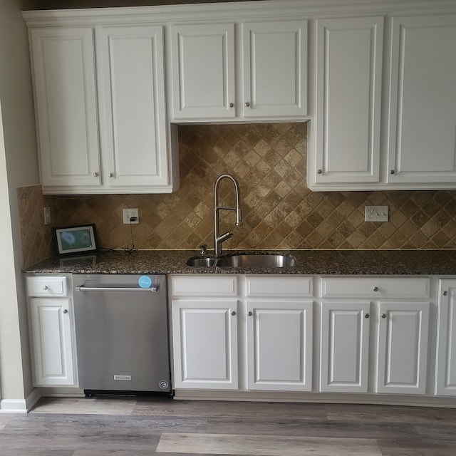 kitchen with white cabinetry, a sink, dark stone countertops, and stainless steel dishwasher