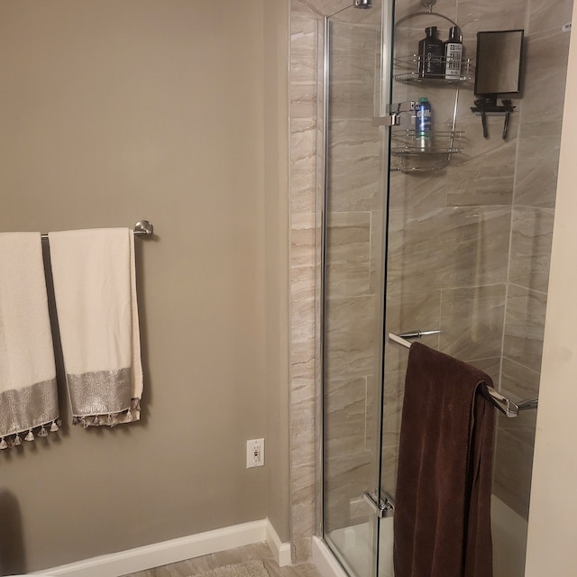full bathroom featuring a stall shower and baseboards