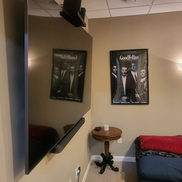 interior space featuring baseboards, a paneled ceiling, and carpet