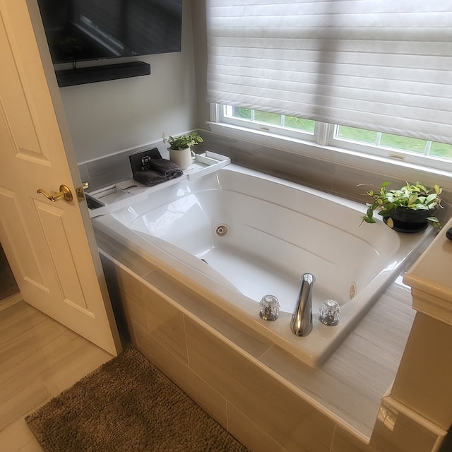 full bath featuring wood finished floors and a whirlpool tub