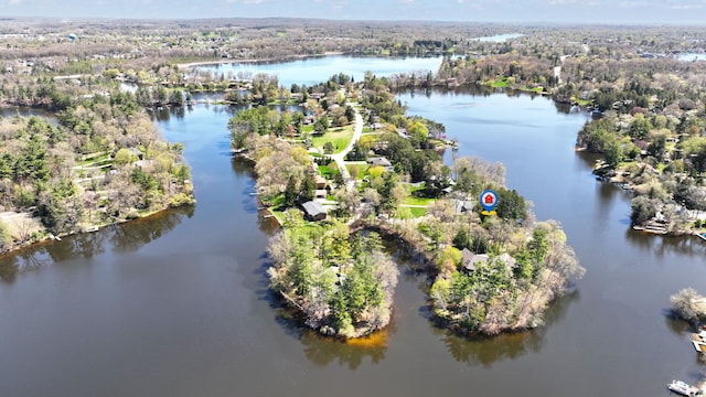 birds eye view of property featuring a water view and a wooded view