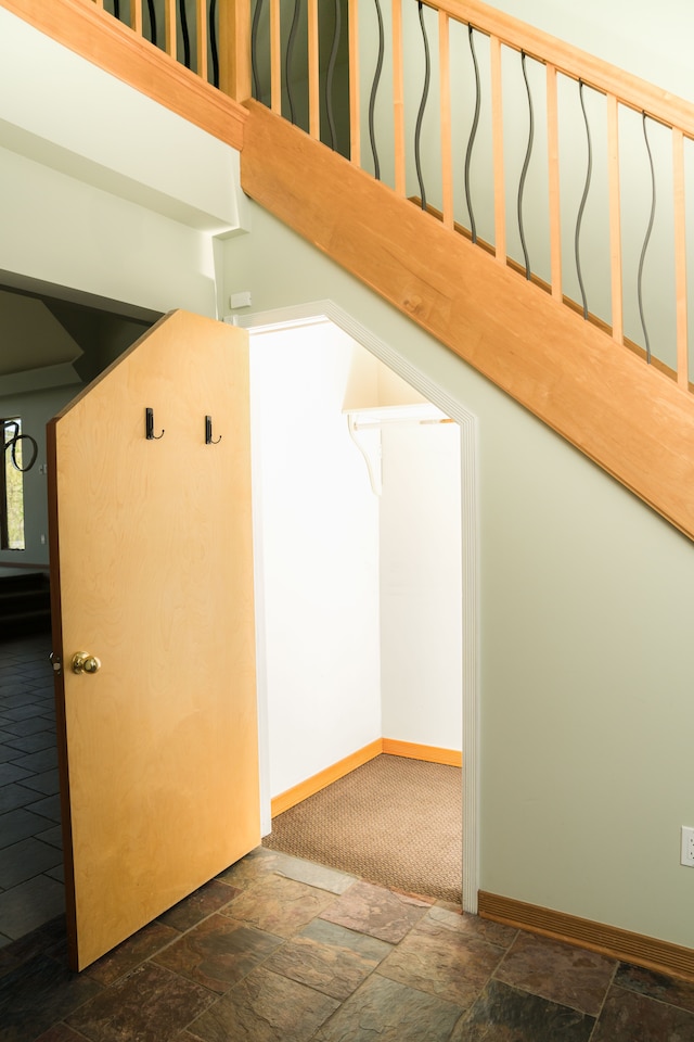 additional living space featuring baseboards and stone finish flooring