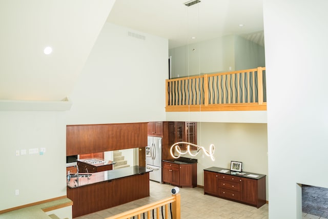 1151 Abseguami Trl, Lake Orion, MI 48362 - kitchen featuring stainless steel fridge, dark countertops, a sink, a chandelier, and brown cabinets