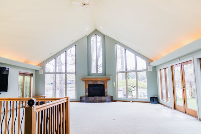 1151 Abseguami Trl, Lake Orion, MI 48362 - carpeted living area featuring high vaulted ceiling, a tile fireplace, french doors, ceiling fan, and baseboards