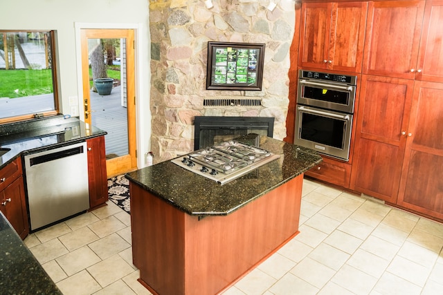 1151 Abseguami Trl, Lake Orion, MI 48362 - kitchen with stainless steel appliances, light tile patterned floors, dark stone counters, and a center island