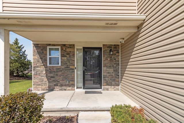 13943 Breakfast Dr, Redford, MI 48239 - doorway to property featuring covered porch and stone siding
