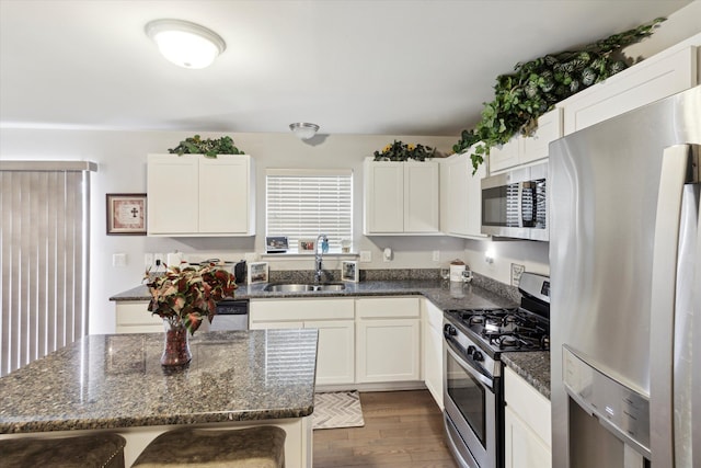 13943 Breakfast Dr, Redford, MI 48239 - kitchen with dark wood finished floors, a sink, white cabinetry, stainless steel appliances, and dark stone counters