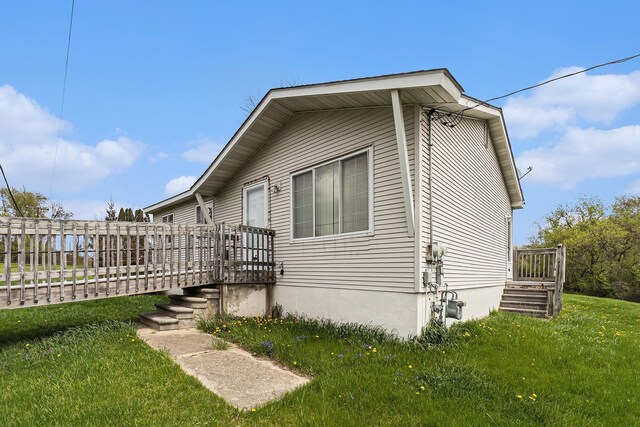 view of side of property with a wooden deck and a yard