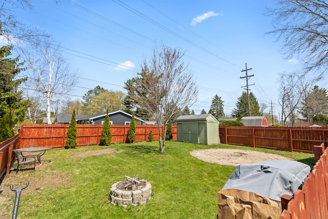 view of yard with a shed, a fire pit, an outdoor structure, and a patio area
