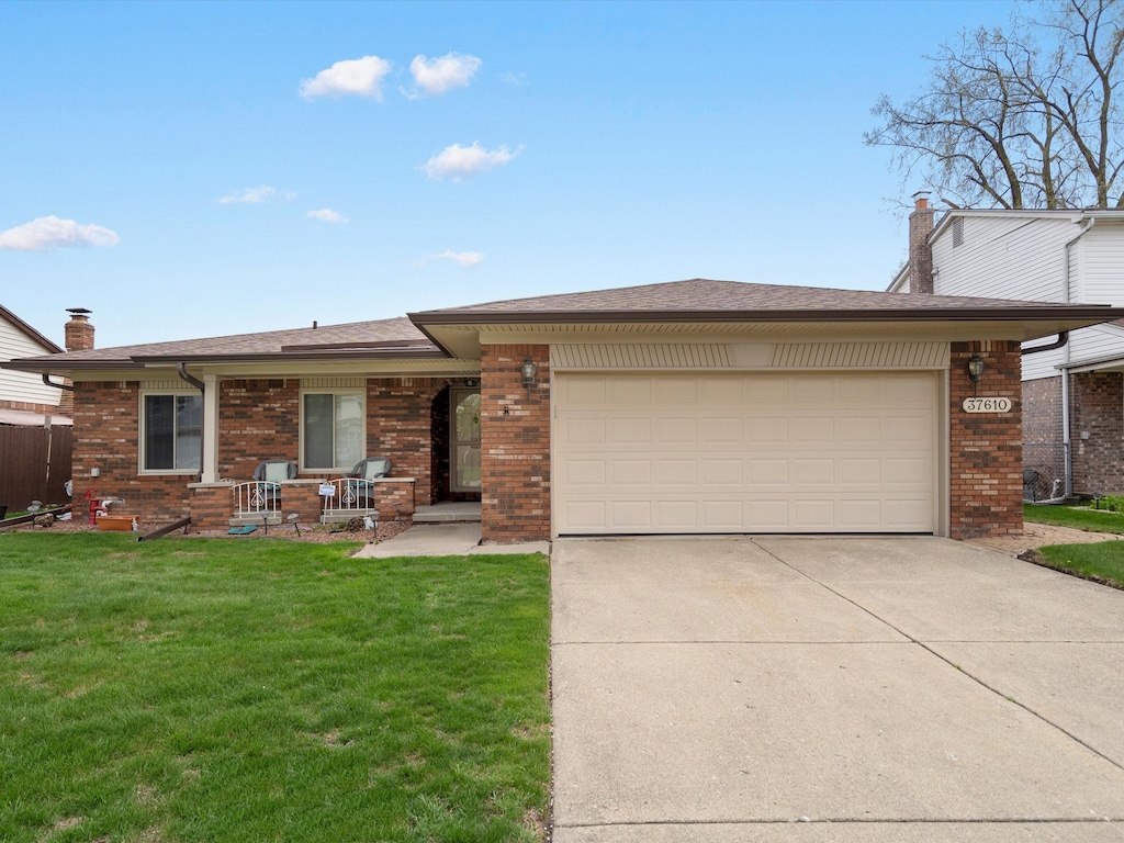 37610 Evergreen Dr, Sterling Heights, MI 48310 - view of front of home featuring brick siding, a garage, a front yard, and concrete driveway
