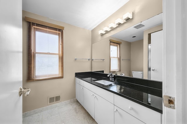 bathroom featuring toilet, visible vents, a wealth of natural light, and marble finish floor
