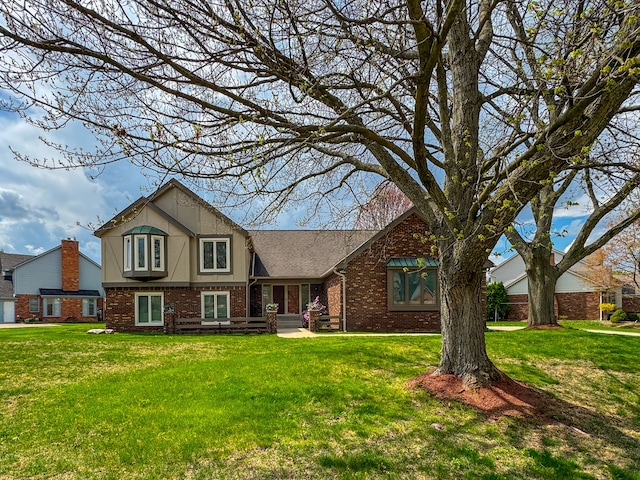 traditional home with brick siding and a front yard