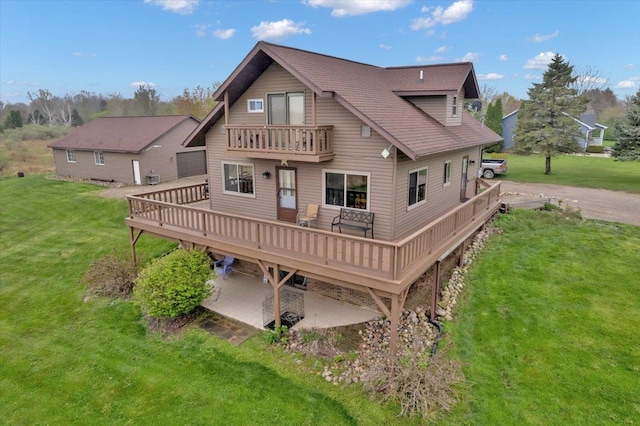 rear view of property featuring a lawn, a wooden deck, and a balcony