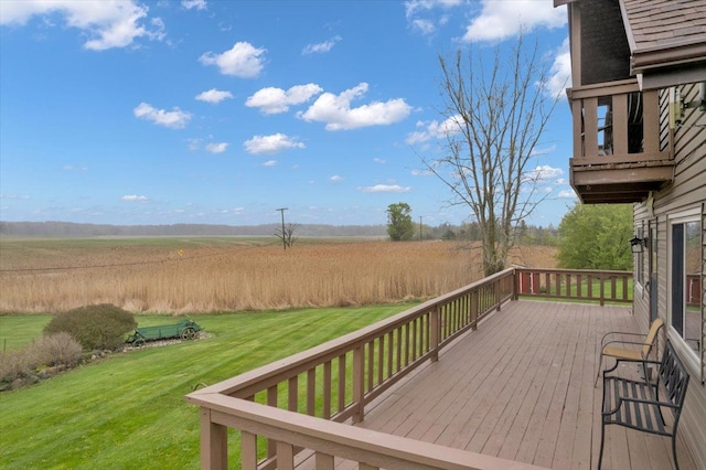 wooden deck featuring a yard and a rural view