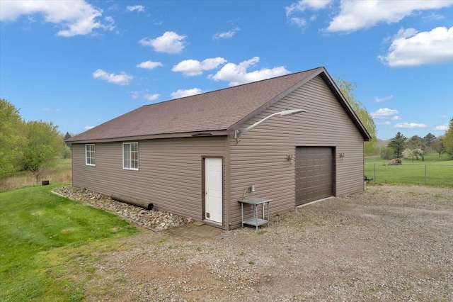detached garage featuring fence and driveway