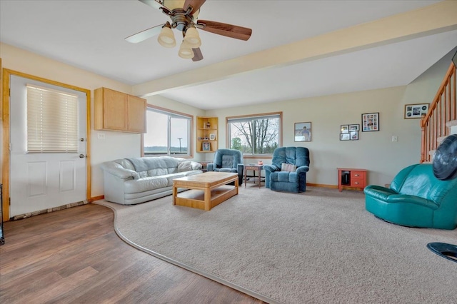 living room with wood finished floors, a ceiling fan, beam ceiling, stairway, and baseboards