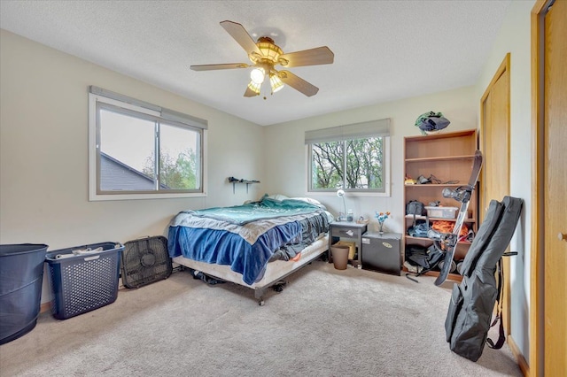 bedroom featuring a textured ceiling, carpet, and a ceiling fan