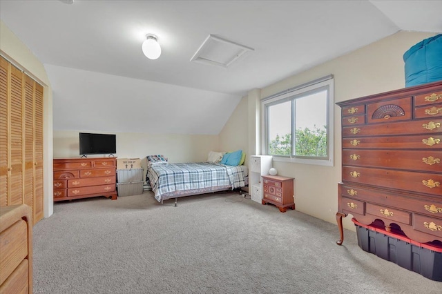 bedroom with lofted ceiling, carpet flooring, a closet, and attic access
