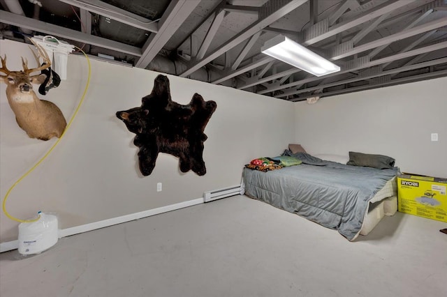 bedroom with concrete floors and a baseboard heating unit