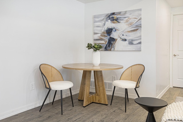 dining area featuring baseboards, visible vents, and wood finished floors