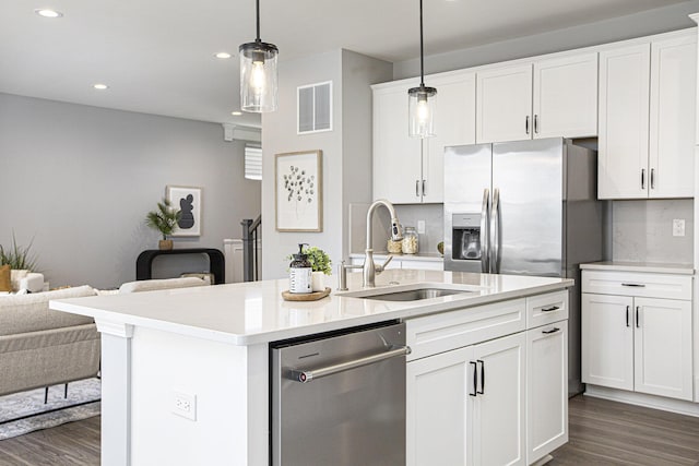 kitchen with stainless steel dishwasher, visible vents, open floor plan, dark wood-type flooring, and a sink