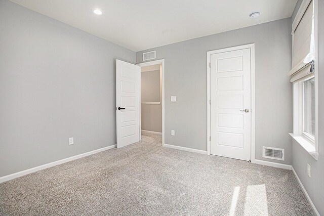 unfurnished bedroom featuring visible vents, recessed lighting, carpet, and baseboards