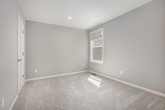 carpeted spare room featuring baseboards, recessed lighting, and visible vents