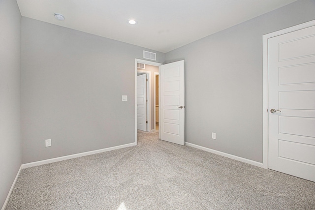 unfurnished bedroom with baseboards, visible vents, recessed lighting, and light colored carpet