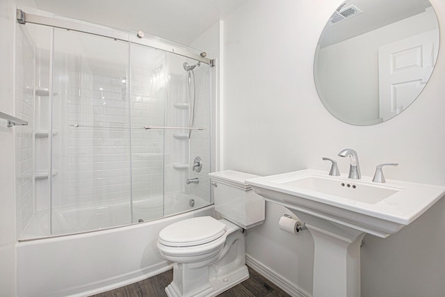 full bathroom with visible vents, wood finished floors, shower / bath combination with glass door, toilet, and baseboards