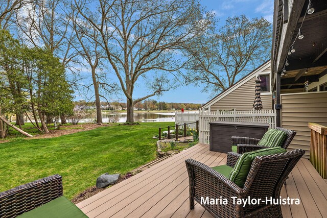 wooden terrace featuring a yard and a water view