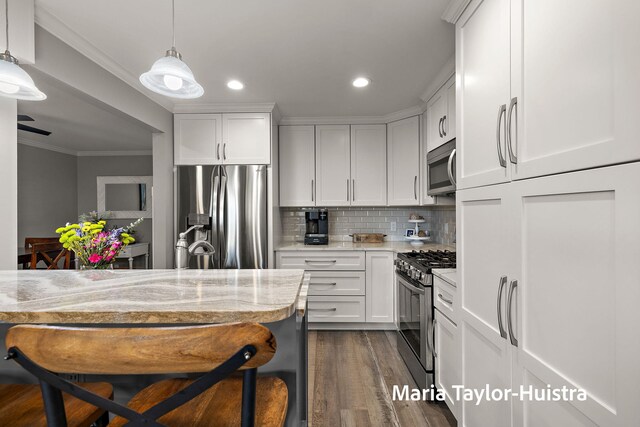 kitchen featuring decorative backsplash, crown molding, stainless steel appliances, recessed lighting, and white cabinetry