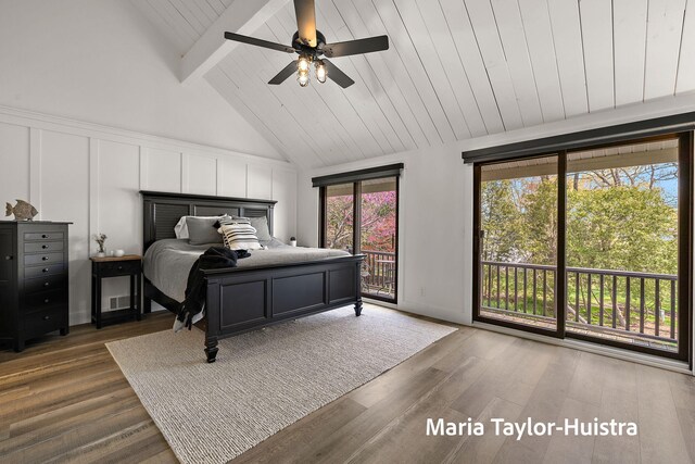 bedroom with access to outside, lofted ceiling with beams, a decorative wall, and wood finished floors