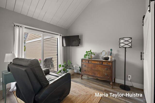 sitting room with wood ceiling, a barn door, wood finished floors, baseboards, and lofted ceiling