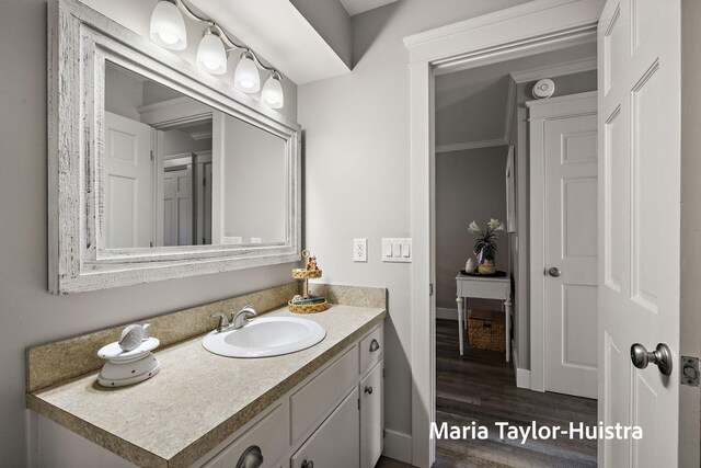 bathroom featuring vanity, baseboards, and wood finished floors