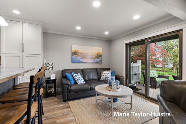 living room featuring recessed lighting, ornamental molding, and light wood-type flooring