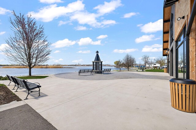 surrounding community with a water view and a patio area