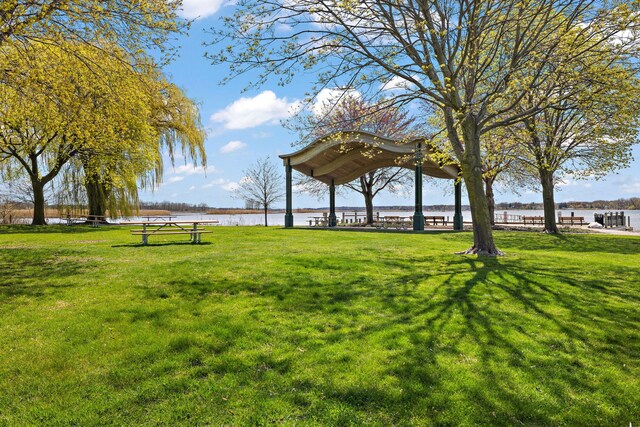 view of property's community featuring a lawn and a water view