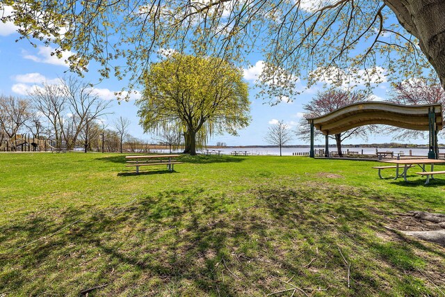 view of home's community with a water view and a yard
