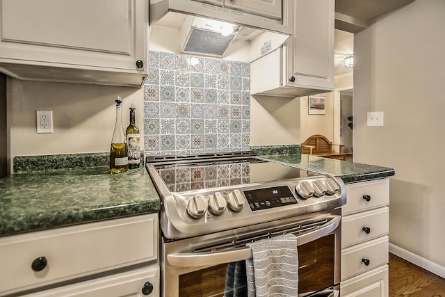 2204 Rivenoak Ct, Ann Arbor, MI 48103 - kitchen featuring wood finished floors, dark countertops, under cabinet range hood, white cabinets, and stainless steel electric stove