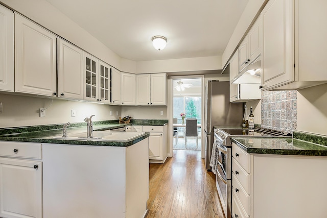 2204 Rivenoak Ct, Ann Arbor, MI 48103 - kitchen with double oven range, dark countertops, white cabinets, under cabinet range hood, and light wood-style flooring