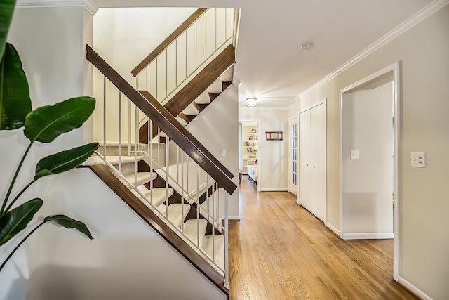 2204 Rivenoak Ct, Ann Arbor, MI 48103 - stairway featuring crown molding, baseboards, and wood finished floors