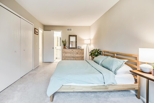 2204 Rivenoak Ct, Ann Arbor, MI 48103 - bedroom featuring visible vents, baseboards, a closet, ensuite bathroom, and light carpet