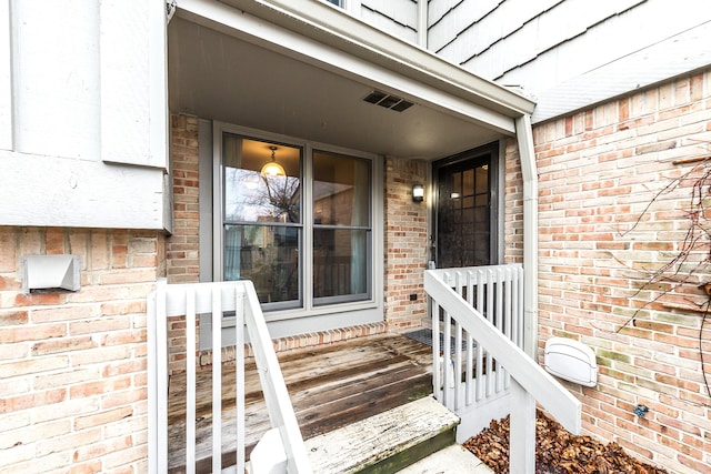 2204 Rivenoak Ct, Ann Arbor, MI 48103 - doorway to property with a porch, visible vents, and brick siding