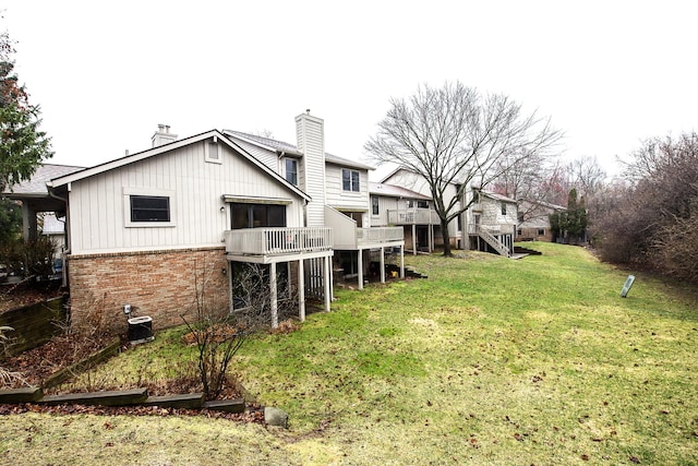 2204 Rivenoak Ct, Ann Arbor, MI 48103 - rear view of house with a wooden deck, a chimney, brick siding, central AC unit, and a lawn